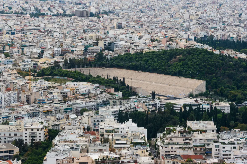 Το Παναθηναϊκό Στάδιο ανάμεσα σε πράσινο και πολυκατοικίες της Αθήνας, από τον λόφο του Λυκαβηττού.