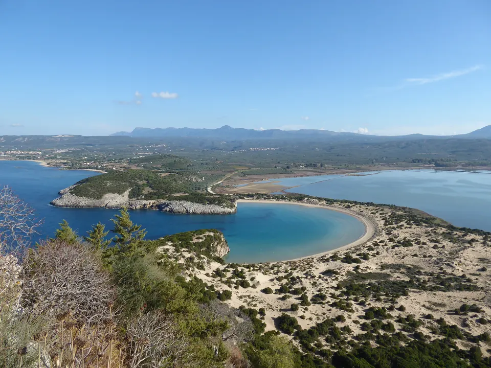 Ο κόλπος της Βοϊδοκοιλιάς από ψηλά: κυκλική αμμώδης παραλία με τιρκουάζ νερά.