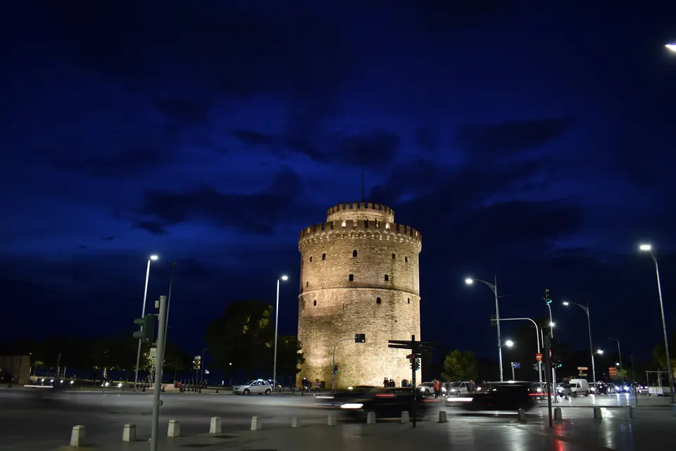 Ο φωτισμένος Λευκός Πύργος της Θεσσαλονίκης το σούρουπο, με σκούρο μπλε ουρανό.